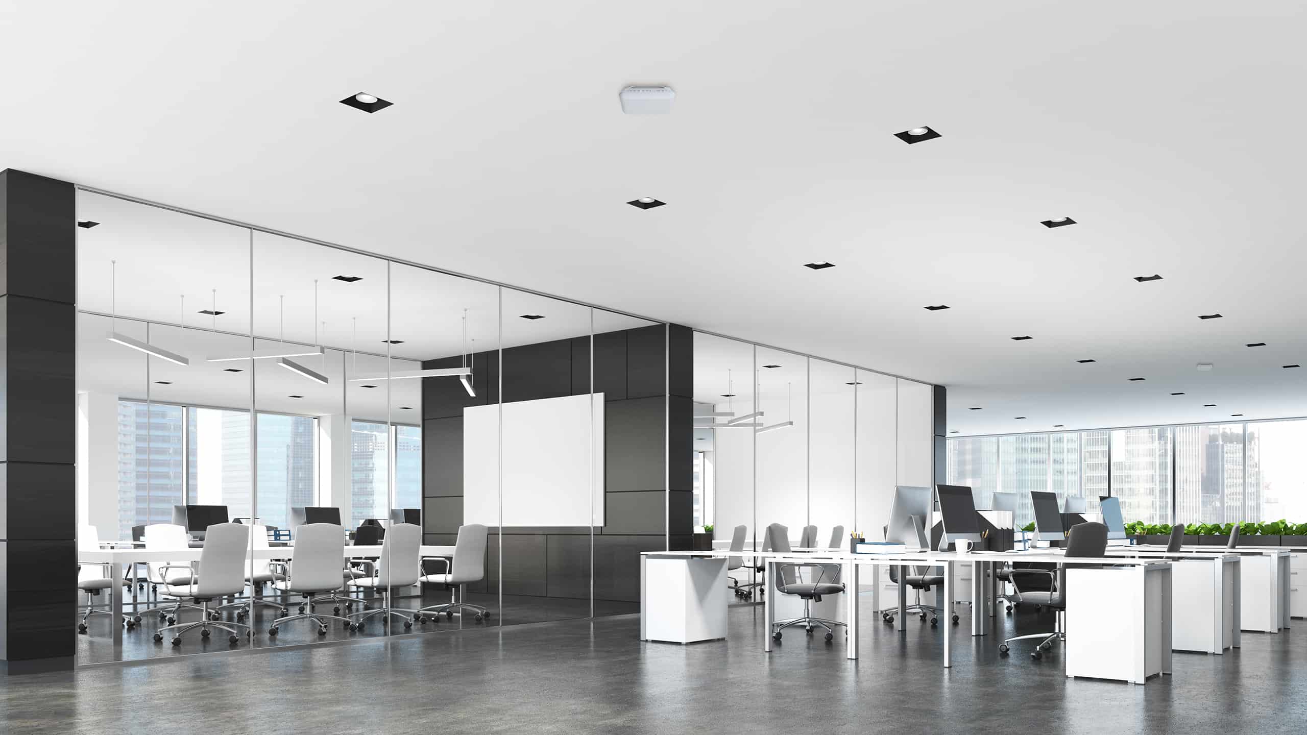 Modern office with open desks, glass conference room, large windows, city view, dark floor, and recessed ceiling lights.