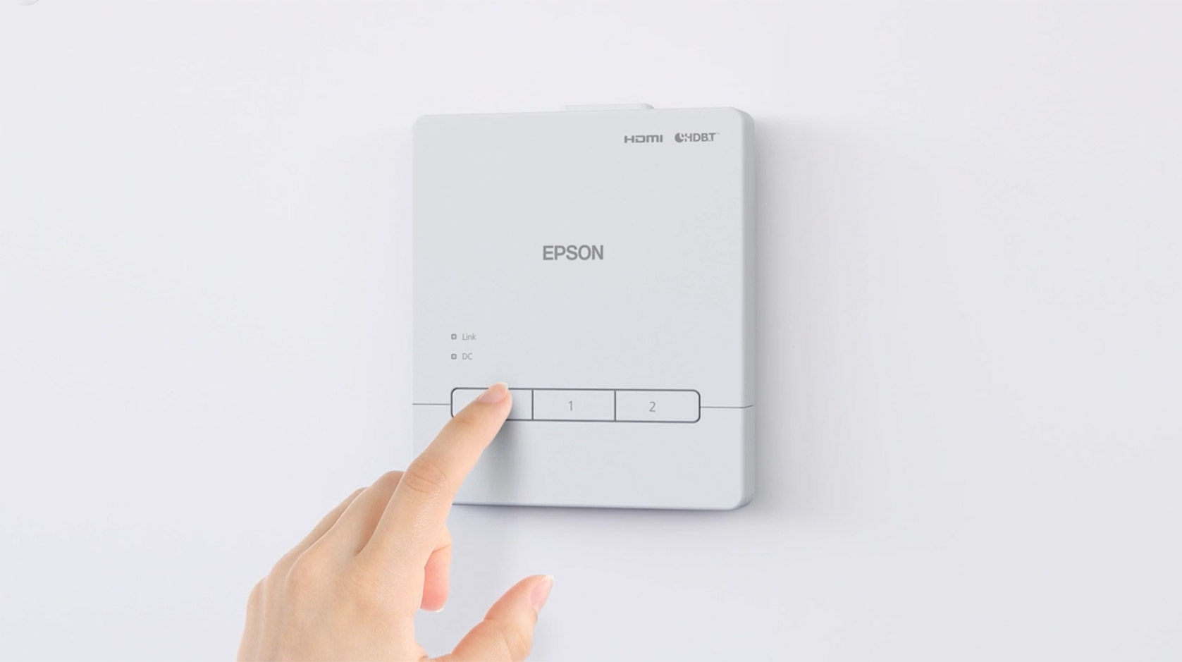 A hand pressing a button on an Epson control unit.